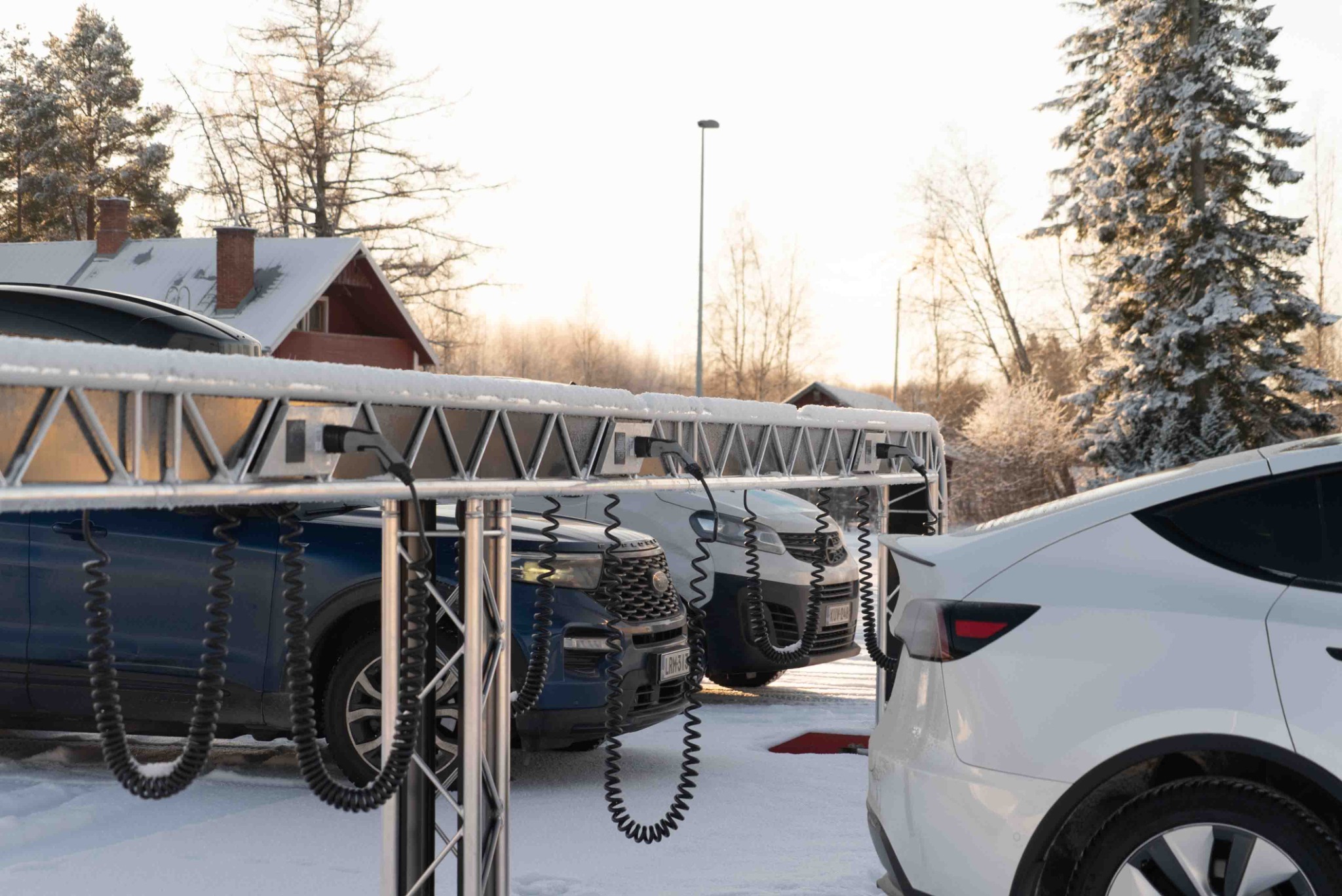 Multiple cars charging from eRail in a snowy car park